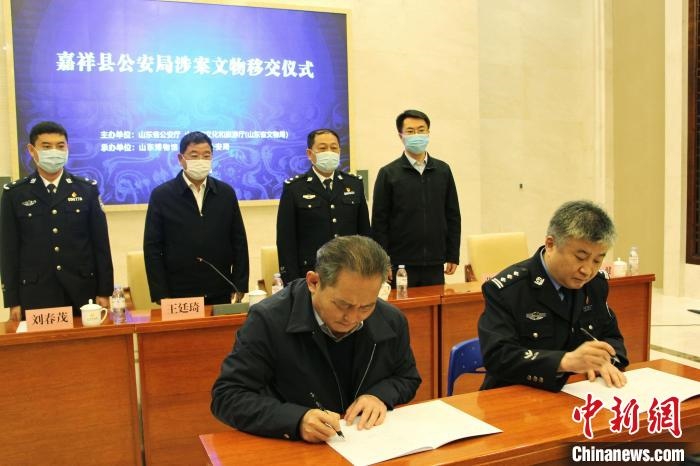 山東博物館館長鄭同修和嘉祥縣人民政府副縣長、公安局局長趙健簽署移交協(xié)議。　趙曉 攝