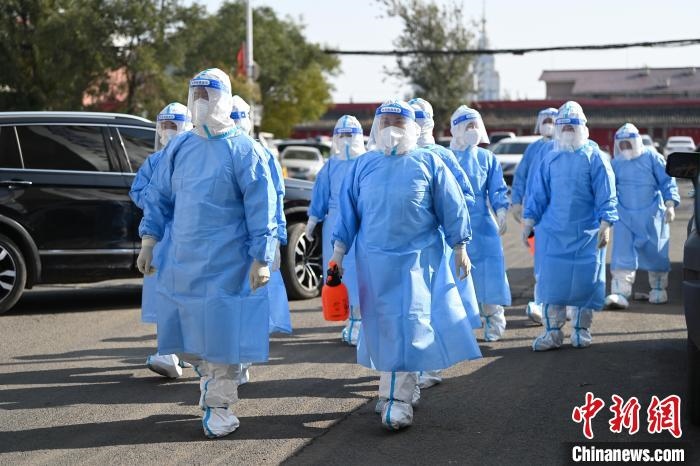 圖為醫(yī)務人員在封閉小區(qū)做防控工作?！⑽娜A 攝