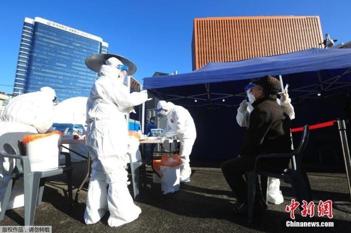 資料圖：韓國(guó)首爾，醫(yī)務(wù)人員對(duì)市民進(jìn)行新冠病毒檢測(cè)。