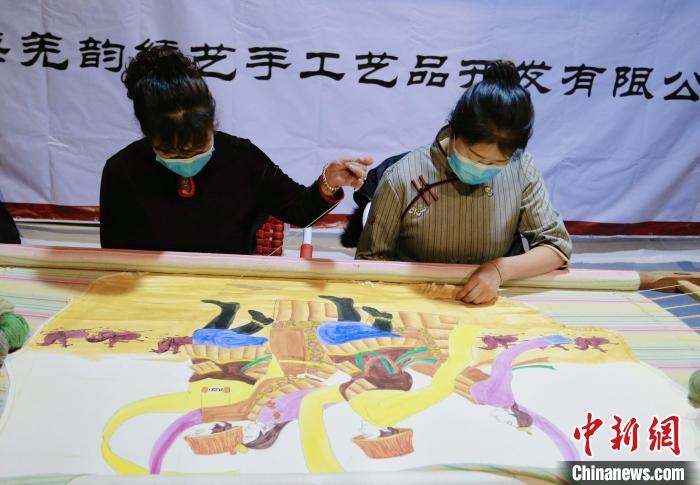 圖為皮繡藝人在市集上“秀”指尖技藝?！●R銘言 攝