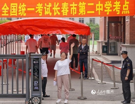 6月7日，在長春市第二中學考點，一名考生信心滿滿進入考場，并與家長揮手致意。人民網記者 李洋攝