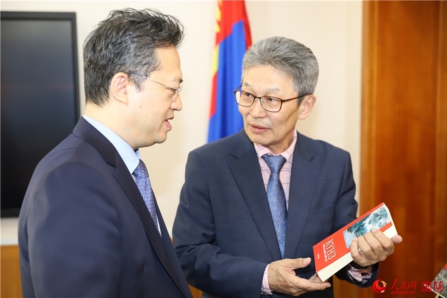 其米德策耶（右一）向李峙介紹翻譯成果。人民網(wǎng)記者 霍文攝