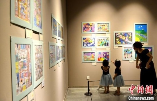 圖為家長(zhǎng)帶著孩子參觀(guān)展覽。呂明 攝