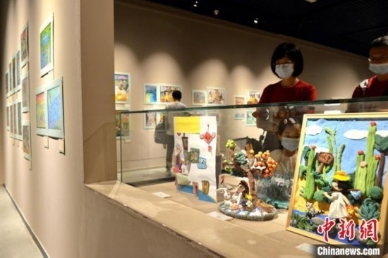 圖為家長(zhǎng)帶著孩子參觀(guān)展覽。呂明 攝