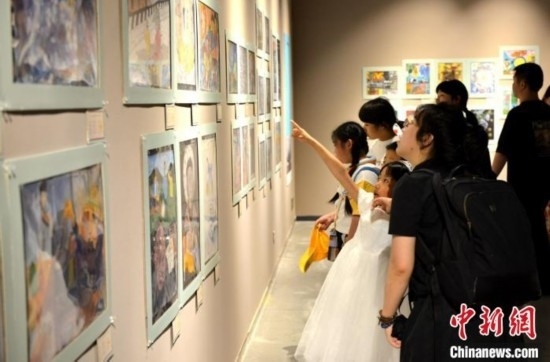 圖為家長(zhǎng)帶著孩子參觀(guān)展覽。呂明 攝