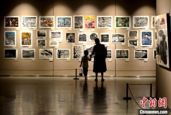 圖為家長(zhǎng)帶著孩子參觀(guān)展覽。呂明 攝