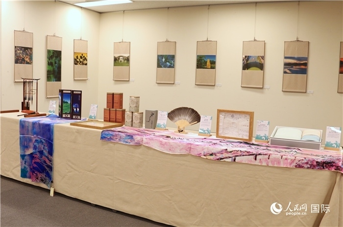 現(xiàn)場展出的馮學敏攝影作品與湖州市特色工藝品。（人民網(wǎng) 許可攝）