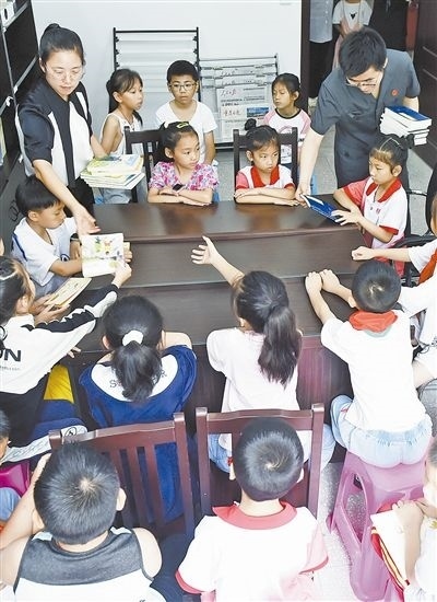  圖④：法院干警為留守兒童發(fā)放暑假讀物。