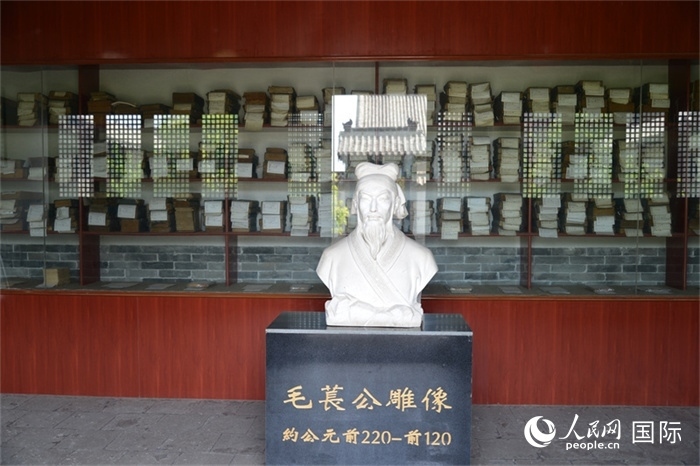 河間詩(shī)經(jīng)齋毛萇雕像。雕像后書(shū)櫥中陳列的是歷代各版本《詩(shī)經(jīng)》及譯本。 人民網(wǎng) 趙昭攝