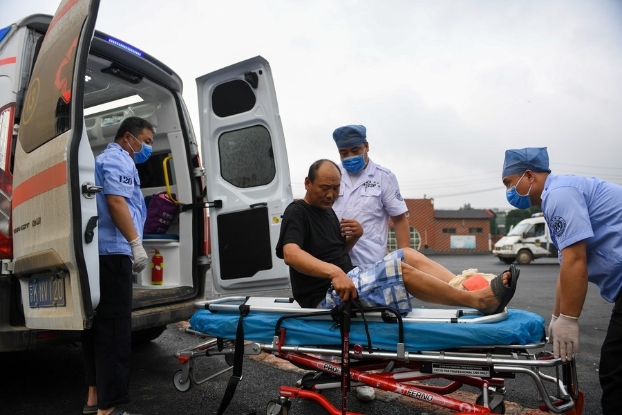 8月1日，在北京市門頭溝區(qū)妙峰山鎮(zhèn)妙峰山民族學(xué)校臨時安置點，北京急救中心工作人員在轉(zhuǎn)運一名受傷村民。新華社記者 鞠煥宗 攝