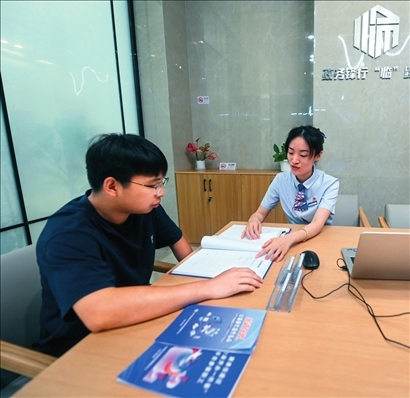 在杭州市臨安區(qū)政務(wù)服務(wù)中心的“為企服務(wù)中心”，黨員志愿者（右）解答企業(yè)主的疑問（2023年7月7日攝）。徐昱攝/本刊