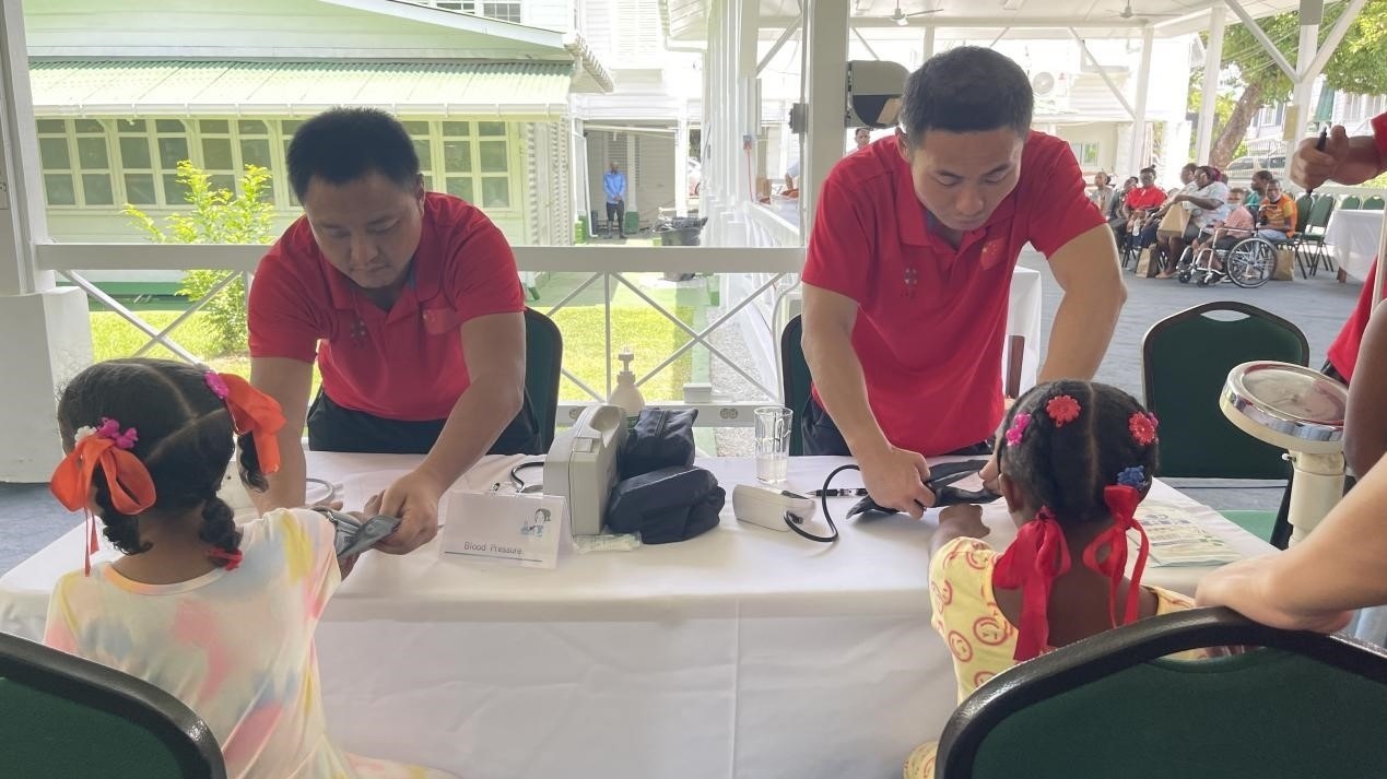 醫(yī)療隊(duì)員為福利院兒童進(jìn)行檢查。第18期援圭亞那醫(yī)療隊(duì)供圖