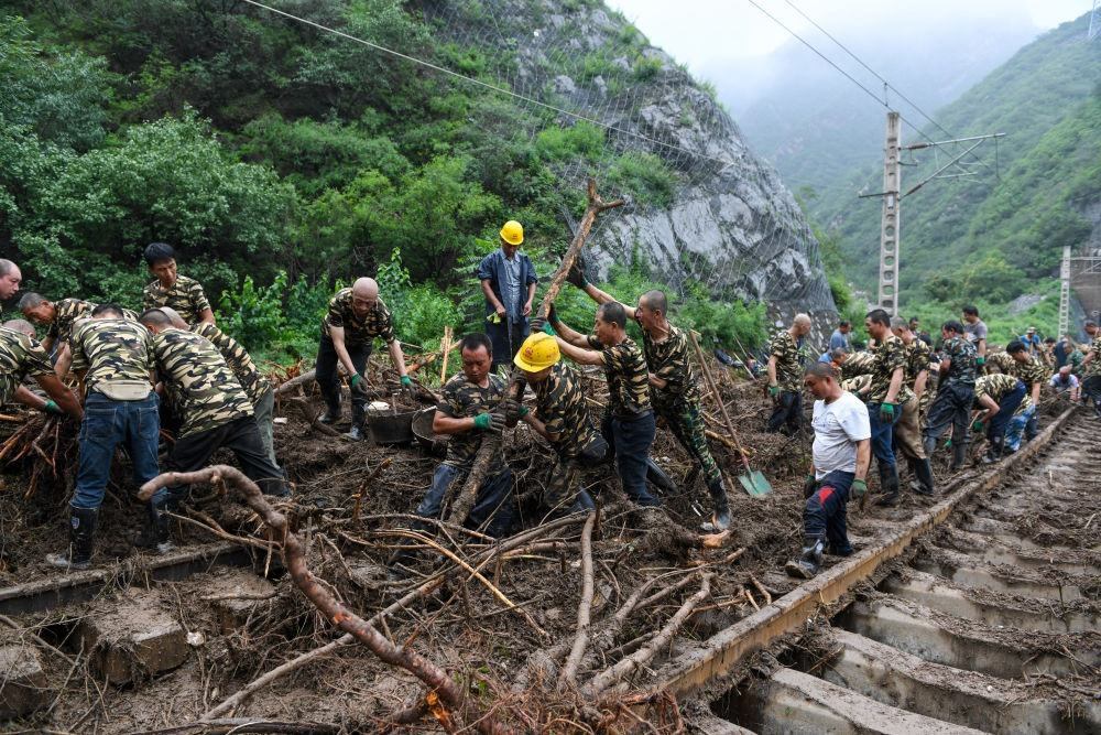 8月1日，在北京市門頭溝區(qū)水峪嘴村附近一段被阻斷的鐵路線上，中鐵六局工作人員在清理軌道上的雜物，全力恢復(fù)交通。新華社記者 鞠煥宗 攝