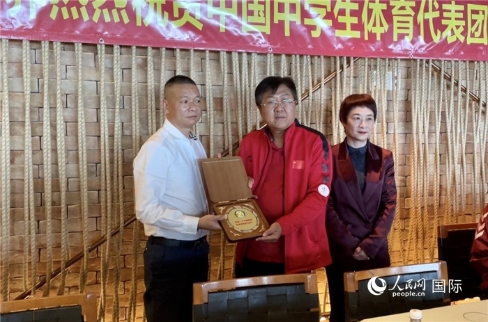 巴西中國和平統(tǒng)一促進會會長王俊曉向中國中學(xué)生體育代表團團長劉立新贈送紀念品。人民網(wǎng)記者 宋亦然攝