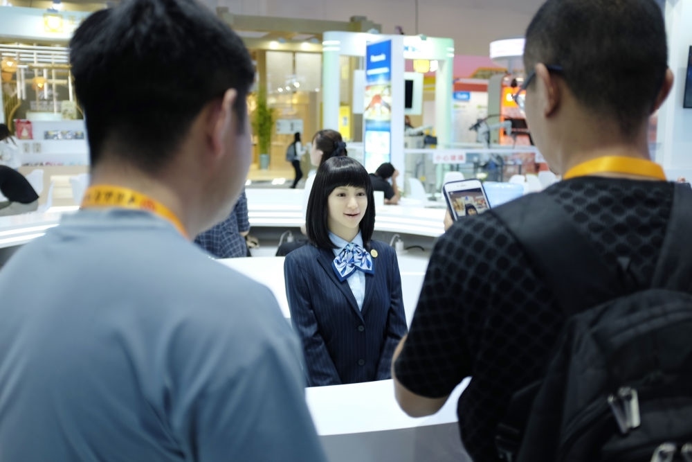 9月1日，媒體記者在國(guó)家會(huì)議中心與服務(wù)機(jī)器人互動(dòng)。新華社記者 劉夢(mèng)琪 攝