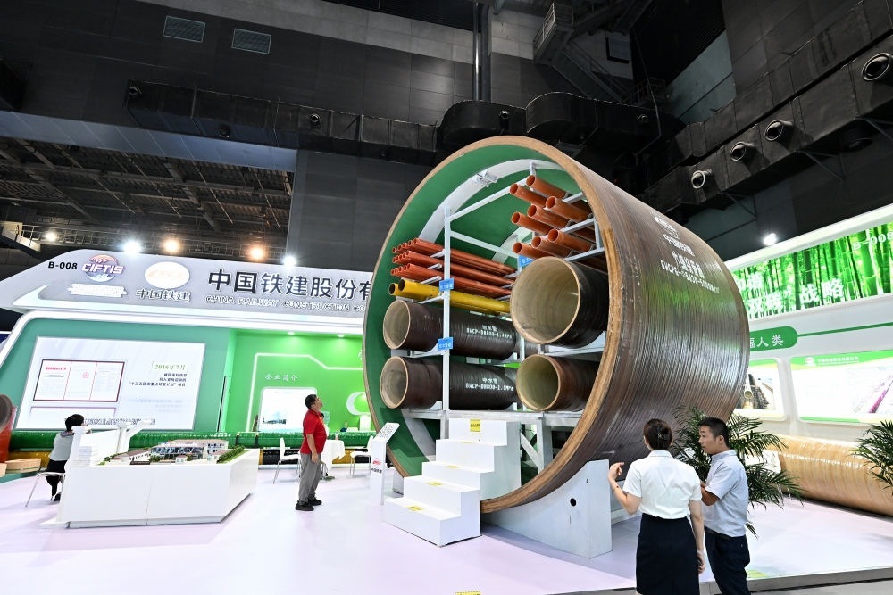 9月2日，在國(guó)家體育館舉行的服貿(mào)會(huì)環(huán)境服務(wù)專題展上，客商在中國(guó)鐵建展位竹纏繞管廊旁了解信息。新華社記者 李鑫 攝
