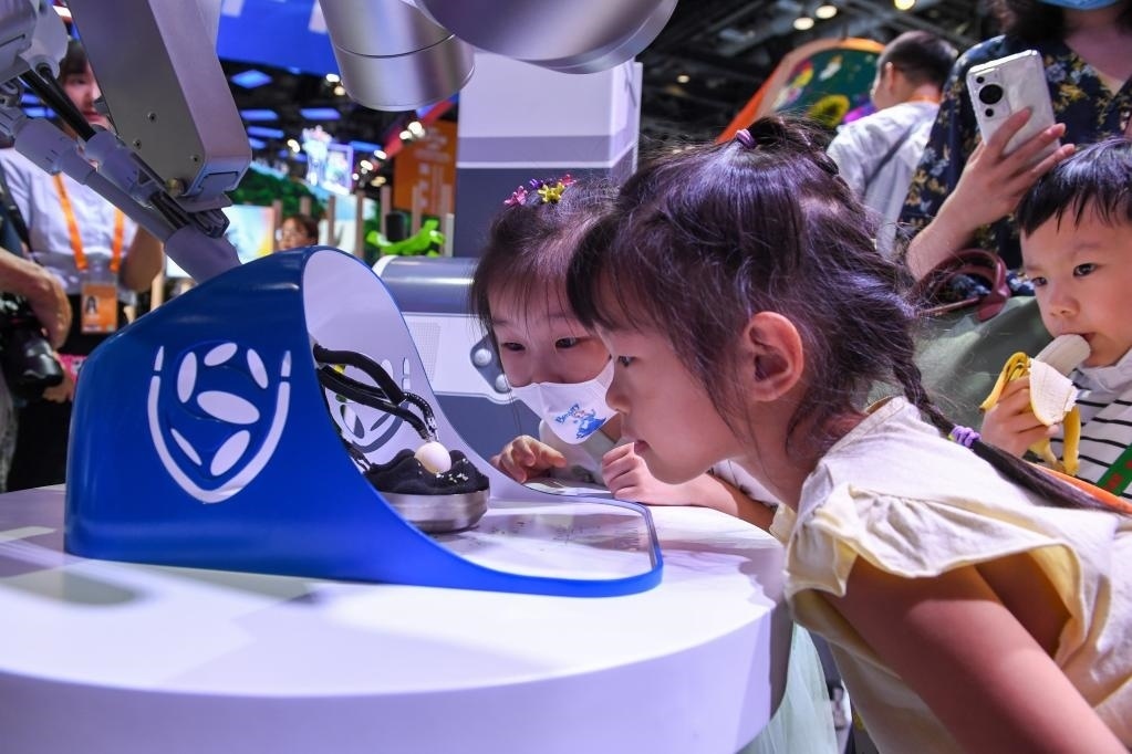9月3日，幾名小朋友在國家會議中心觀看單孔腔鏡手術(shù)機器人展示。新華社記者 鞠煥宗 攝