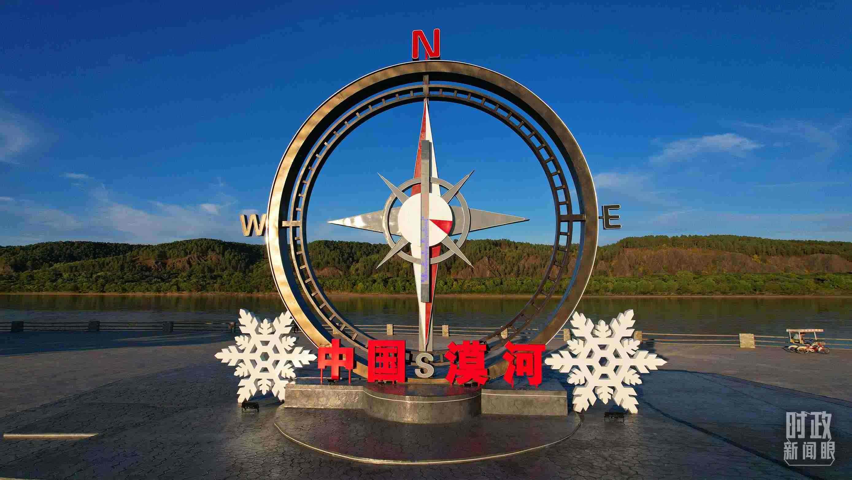 △指北針雕塑是北極村標志性建筑之一，其紅色指針指向正北方。上面的大型溫度計高12.22米，象征北極村位于東經(jīng)122°20′。（總臺央視記者范凱拍攝）