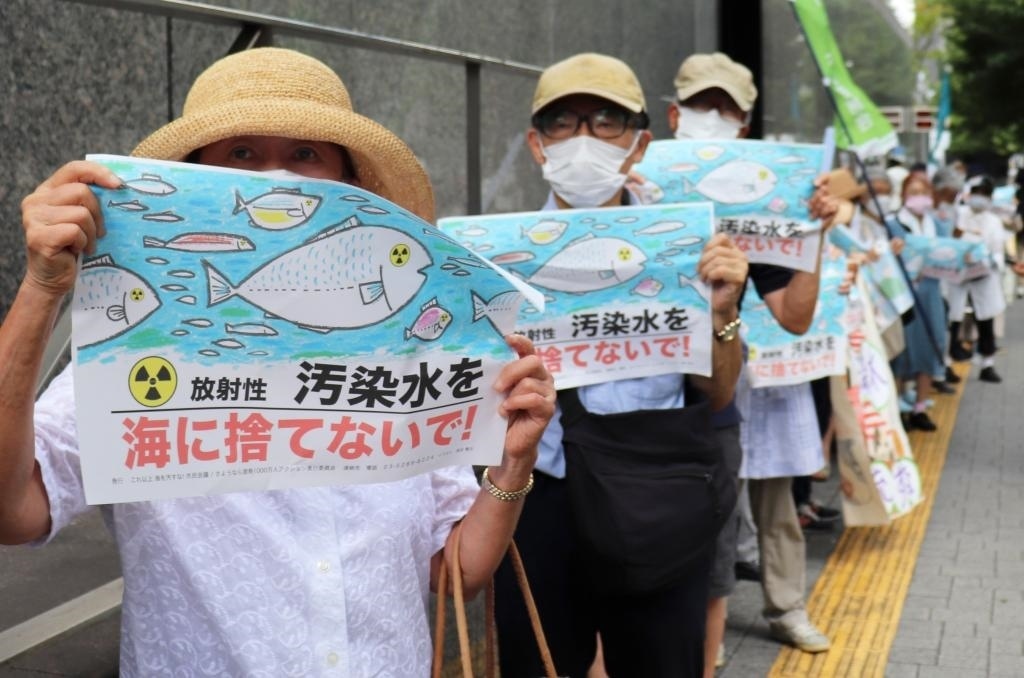 8月24日，日本民眾手持“不要將污染水扔進大?！钡葮苏Z在東京電力公司總部前集會，抗議日本政府和東電公司無視民意啟動核污染水排海。新華社記者楊光攝