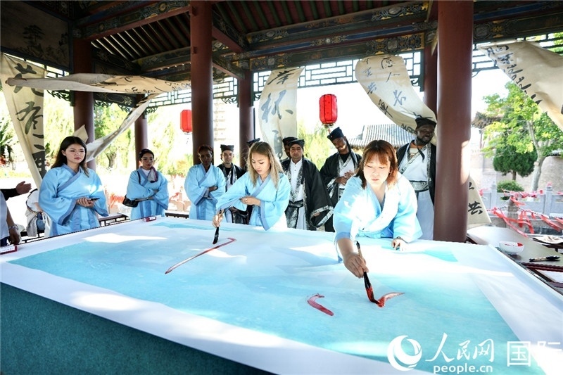 選手們提筆書寫“家園”二字。人民網(wǎng) 盧鵬宇攝