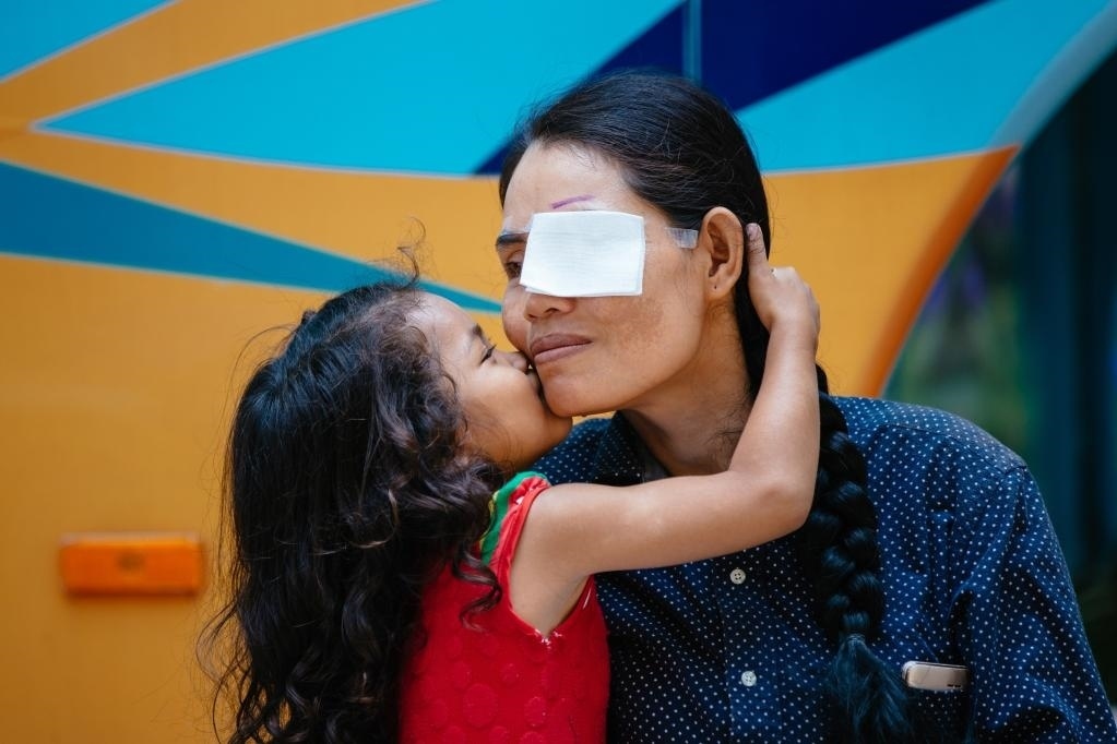 2019年3月15日，在柬埔寨磅湛省醫(yī)院，即將接受白內(nèi)障手術(shù)的患者孫美樂(lè)接受女兒的親吻祝福。在接受了中國(guó)醫(yī)療隊(duì)的白內(nèi)障義診手術(shù)后，她的視力逐步恢復(fù)，生活有了新的光明和希望。