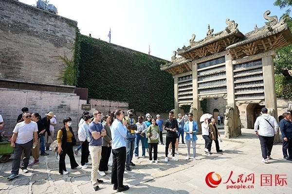 選手們認真聆聽導游講解。人民網(wǎng) 盧鵬宇攝