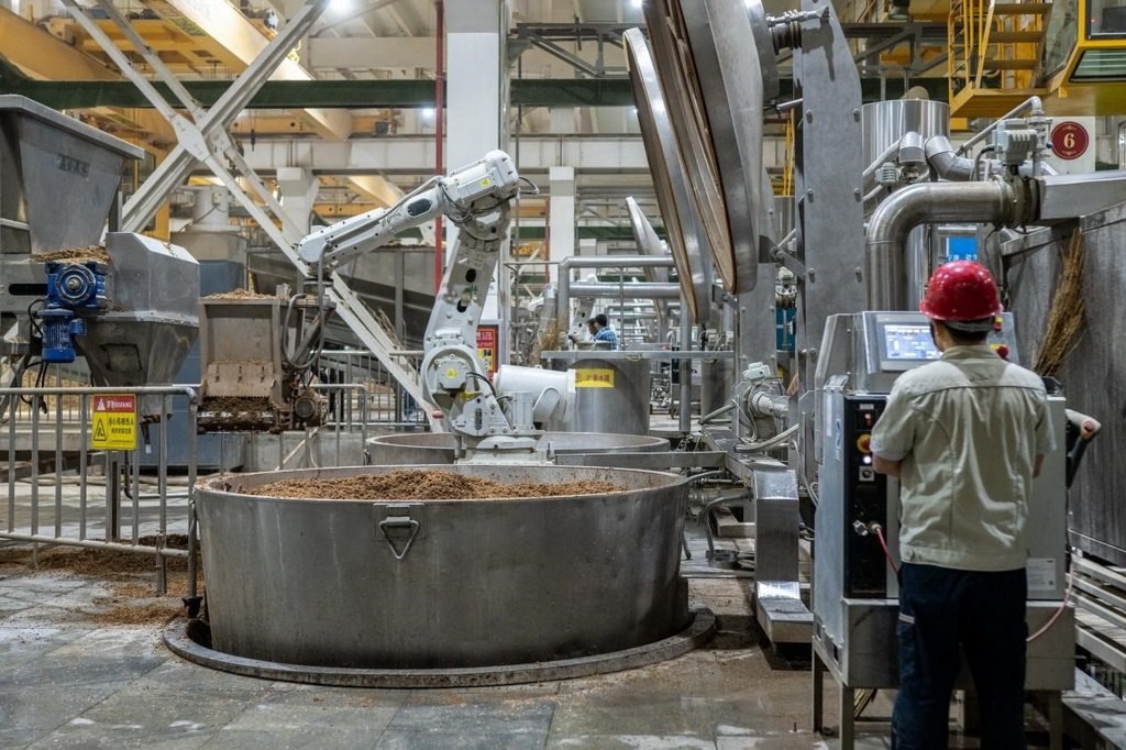 907車間里，機械臂正在撒料裝甑。嚴(yán)磊攝