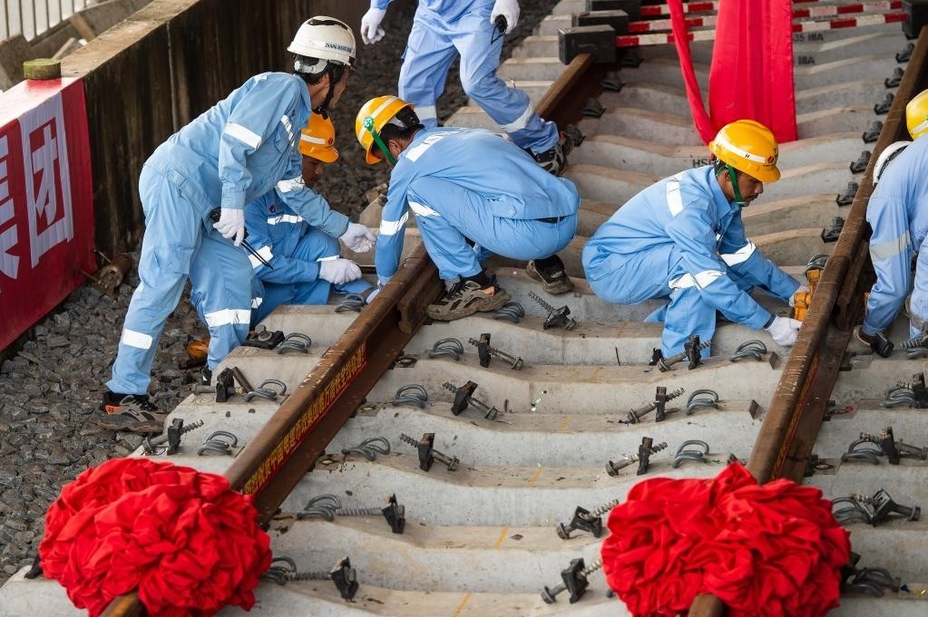 3月31日，在印度尼西亞雅加達(dá)雅萬(wàn)高鐵哈利姆車站，工人鋪設(shè)雅萬(wàn)高鐵全線最后一根鋼軌。