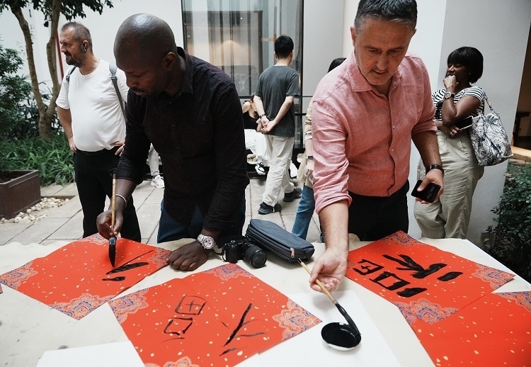 首屆國際傳播“絲路獎”獲獎代表等在廣州市荔灣區(qū)永慶坊參加文化交流活動。楊爍壁、王燕攝影報道