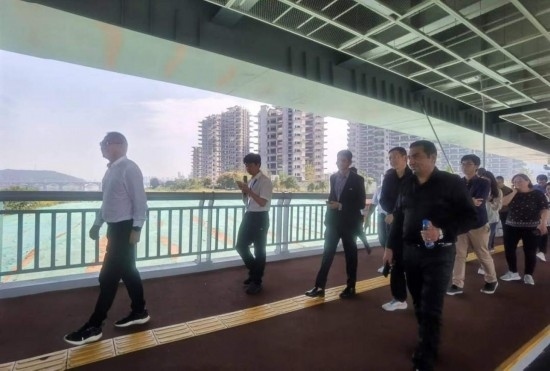 10月24日，2023“一帶一路”媒體合作論壇聯(lián)合采訪團(tuán)團(tuán)員走在清水塘大橋景觀通道上。本報(bào)記者 常雯宜攝