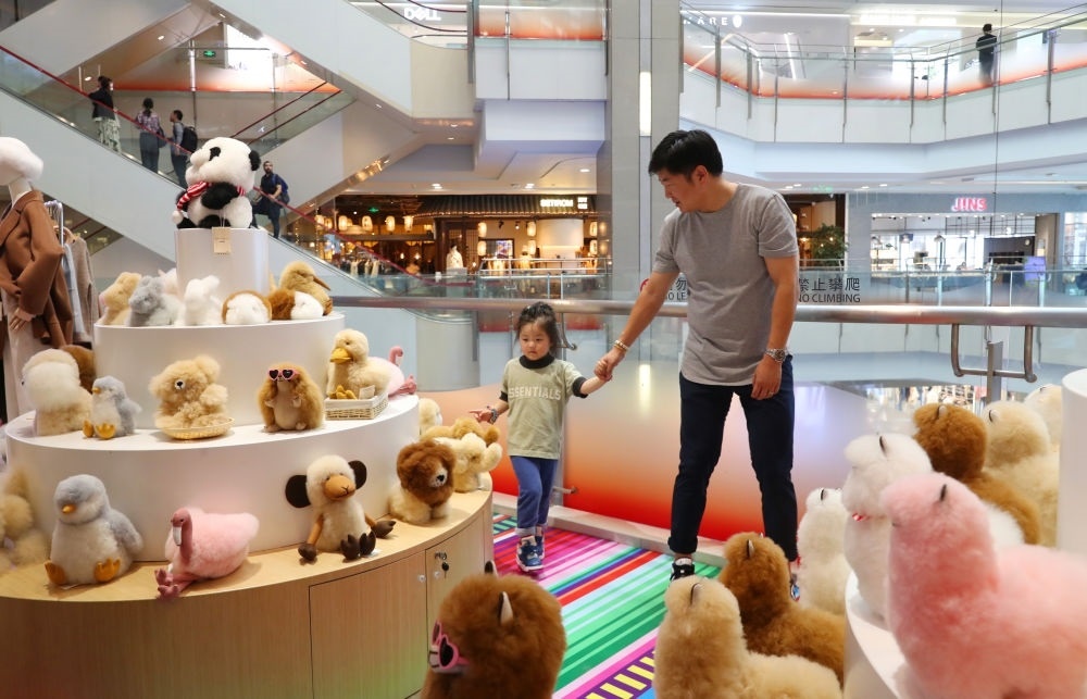 2023年11月2日，顧客在溫暖駝品牌專柜內(nèi)選購。連續(xù)六年參加進(jìn)博會(huì)的秘魯羊駝制品品牌溫暖駝在上海市中心商場開設(shè)了專柜。新華社記者 方喆 攝