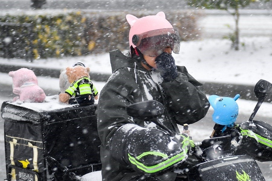 11月6日，在長春市街頭，一名外賣員在雪中騎行。新華社記者 許暢 攝