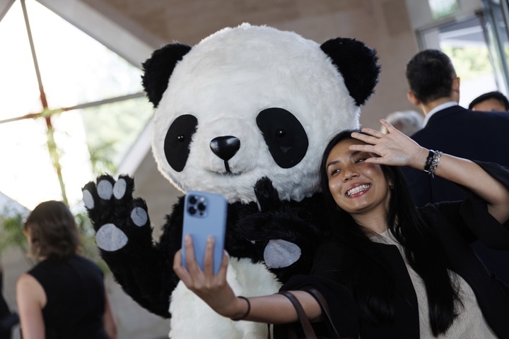 2022年8月24日，在美國(guó)華盛頓中國(guó)駐美國(guó)大使館，來(lái)賓與大熊貓玩偶合影。