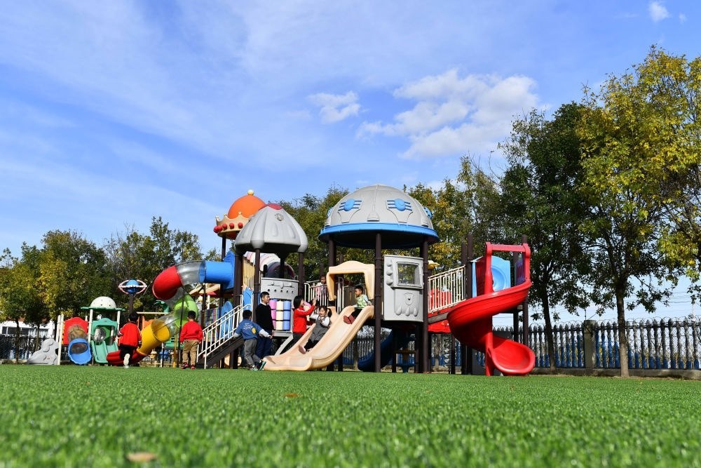 在山東省東營(yíng)市墾利區(qū)楊廟社區(qū)幼兒園，孩子們?cè)诶蠋煹膸ьI(lǐng)下進(jìn)行戶外活動(dòng)（2021年10月19日攝）。新華社記者 郭緒雷 攝