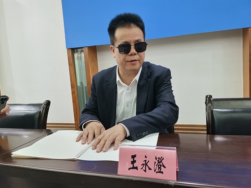 全國人大代表王永澄正在閱讀盲文版代表建議答復(fù)。本報(bào)記者 張 璁?dāng)z