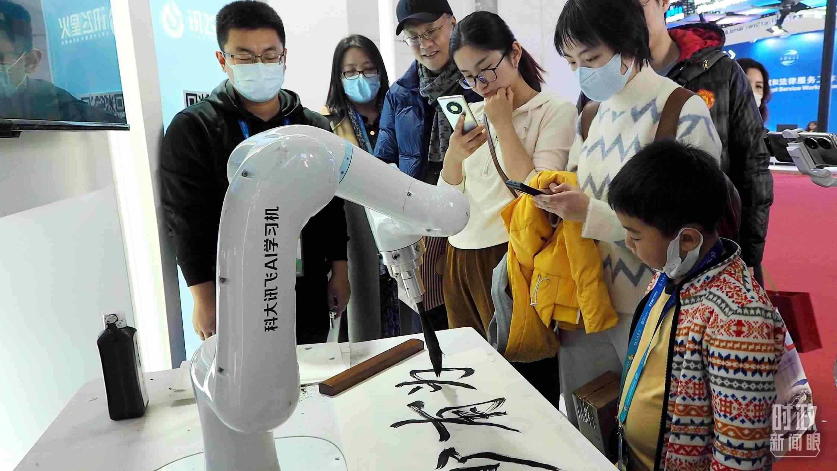 △觀眾在首屆鏈博會(huì)上體驗(yàn)AI書法機(jī)器人。