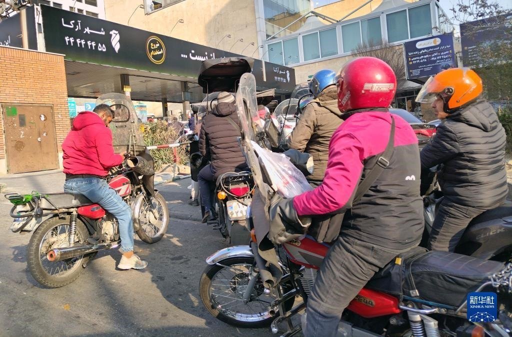 12月18日，摩托車在伊朗首都德黑蘭的一家加油站外等待加油。新華社記者 沙達(dá)提 攝