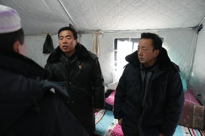 2023年12月22日，積石山縣大河家鎮(zhèn)大河村黨支部書記馬成忠（右二）在帳篷里和受災(zāi)群眾交流。新華社記者 陳斌 攝