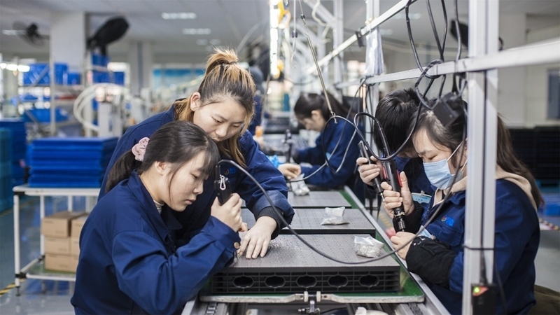 在新亞勝光電的產(chǎn)品線上，工人正進(jìn)行產(chǎn)品組建和安裝布線。受訪者供圖