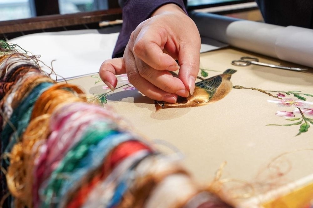 △2023年7月6日，盧建英在江蘇蘇州平江路的工作室內(nèi)刺繡。