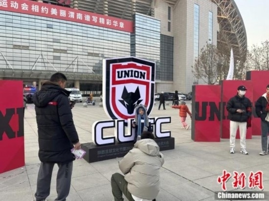 球迷們與隊(duì)徽合影。記者 卞立群 攝