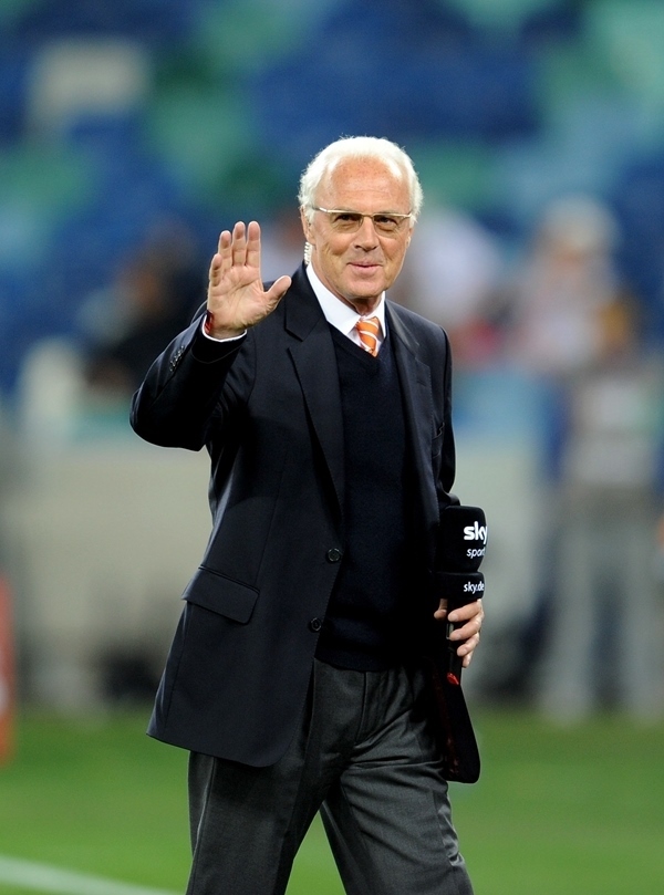 這是2010年7月7日，在南非德班舉行的2010年足球世界杯德國隊對陣西班牙隊的半決賽前，貝肯鮑爾接受電視臺采訪時和友人打招呼。新華社記者 王毓國 攝