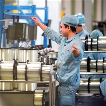 在位于武漢的長(zhǎng)飛光纖光纜股份有限公司光纖生產(chǎn)車間內(nèi)，工作人員對(duì)光纖進(jìn)行檢測(cè)（資料圖片）。肖藝九攝/本刊