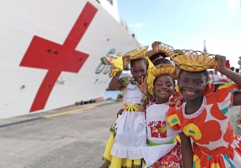 2018年10月，在安提瓜和巴布達首都圣約翰，當(dāng)?shù)匦∨笥焉泶﹤鹘y(tǒng)服裝歡迎中國海軍“和平方舟”醫(yī)院船首次到訪。