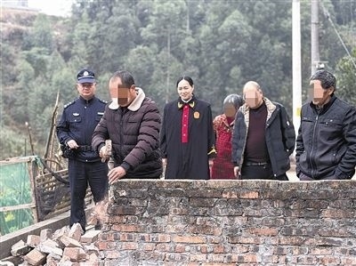  圖③：庭審結(jié)束后，在法官的見證下，陳某在院壩邊重新開鑿一條通道。