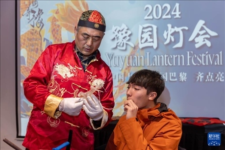 1月28日，在上海豫園舉行的民俗活動(dòng)上，美國(guó)馬斯卡廷中學(xué)學(xué)生在非遺傳承人的指導(dǎo)下吹糖偶。 新華社記者 王翔 攝