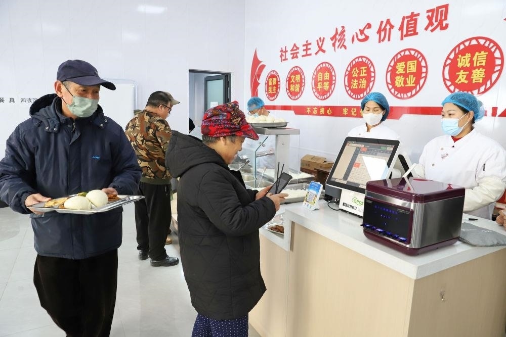 △2024年2月1日，市民在河北涿州市雙塔街道永濟(jì)秀園小區(qū)便民食堂內(nèi)購買午餐。