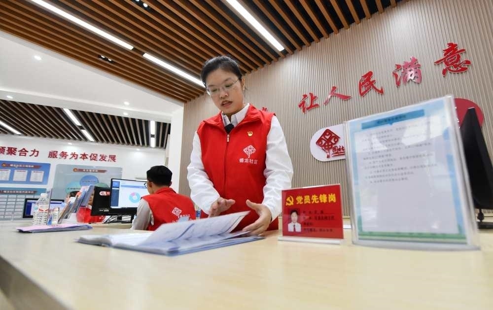 △2023年12月14日，廣西南寧市蟠龍社區(qū)，工作人員在為居民服務(wù)。