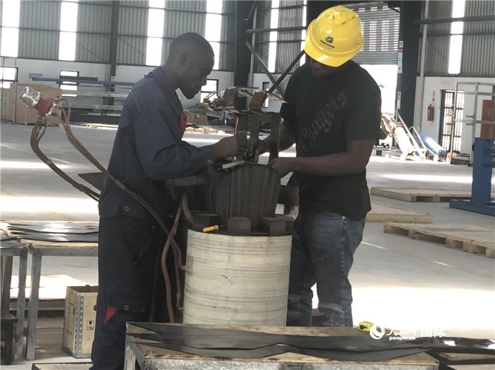 經(jīng)貿(mào)合作區(qū)廠房?jī)?nèi)，當(dāng)?shù)毓と苏诰o張作業(yè)。人民網(wǎng)記者 黃培昭攝