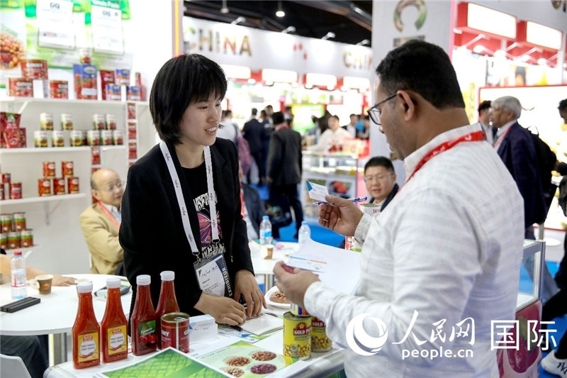 圖為中國參展企業(yè)代表與采購商交流。人民網(wǎng) 塔里克·易卜拉欣攝